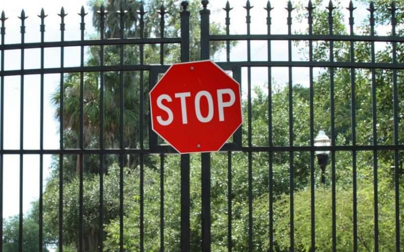 closed gate with stop sign