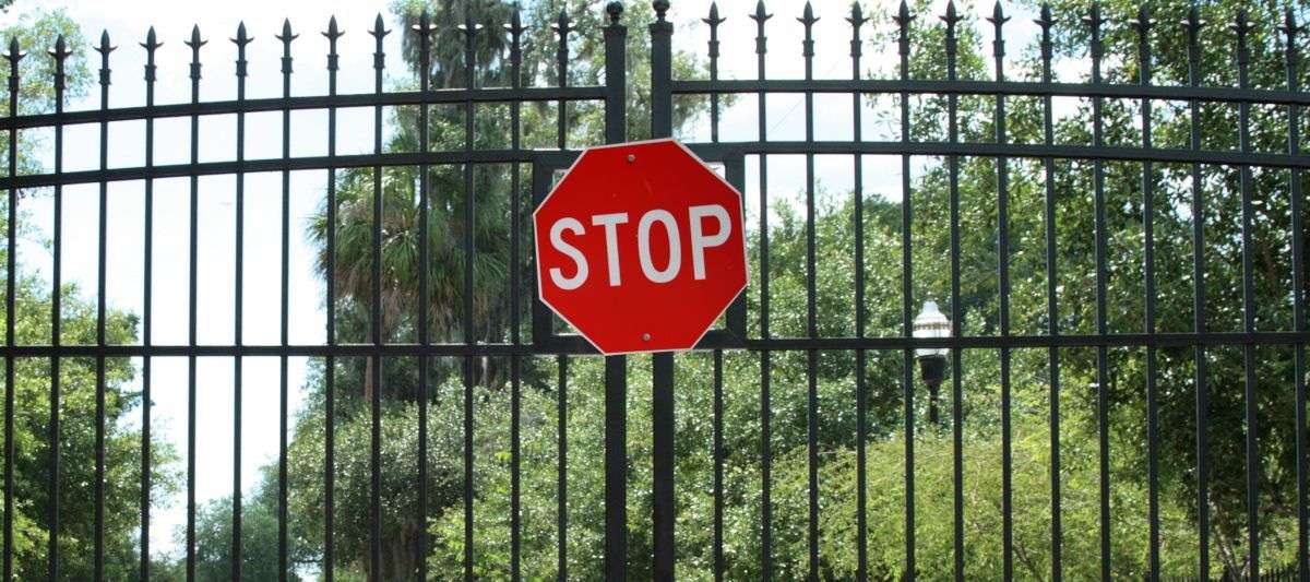 closed gate with stop sign