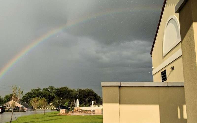 Faith Amidst Adversity symbolized by a rainbow at church