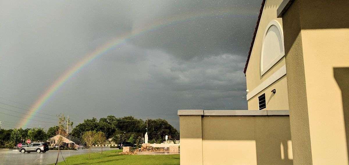 Faith Amidst Adversity symbolized by a rainbow at church