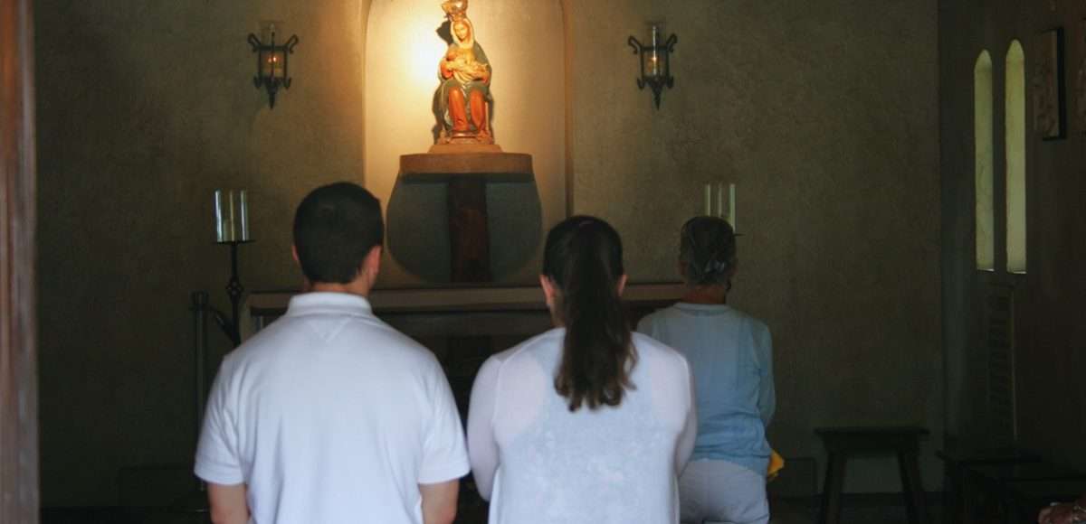 Gen Z couple praying at the Shrine of La Leche