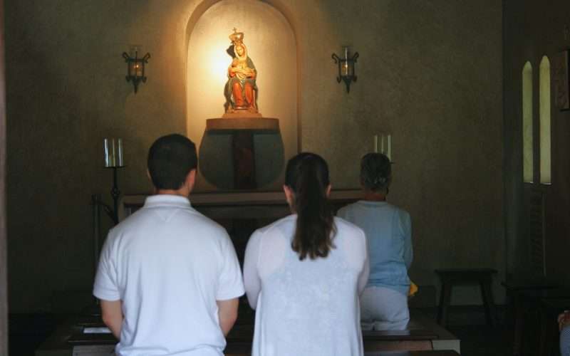 Gen Z couple praying at the Shrine of La Leche